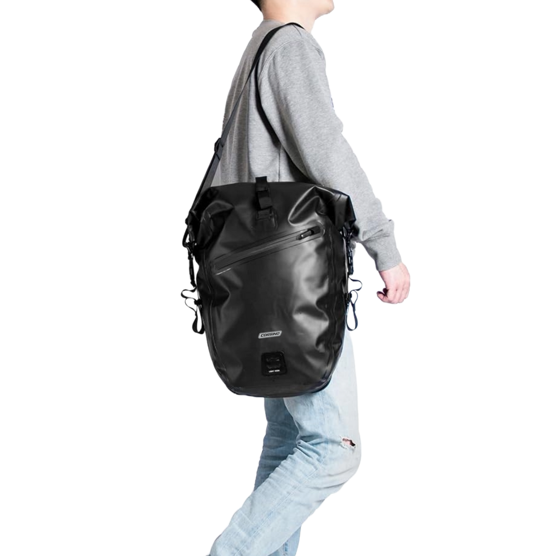 Black Corsino Journey Pannier Bag 27L carried on a shoulder with the included strap, demonstrating its versatile off-bike transport options.