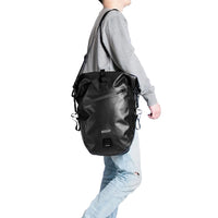 Black Corsino Journey Pannier Bag 27L carried on a shoulder with the included strap, demonstrating its versatile off-bike transport options.