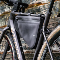 Black bike frame bag attached to a gravel bike frame, made of waterproof 840D Nylon TPU. Dimensions: 39.5x6x23/10 cm, weight: 330g. Features a 3-layer support structure to maintain shape under load, and is both waterproof and scratch-resistant.