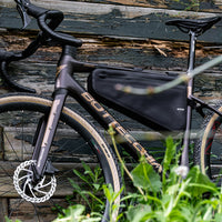 Waterproof black bike frame bag secured to a gravel bike frame, made from durable 840D Nylon TPU. Measures 39.5x6x23/10 cm, weighing 330g. Equipped with a 3-layer support structure to ensure shape retention under load, and offers both waterproofing and scratch resistance.