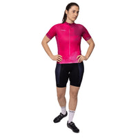 Female cyclist wearing the pink Corsino Cloud short sleeve jersey from the front, highlighting the sleek full covered zipper and 4cm compression cuffs on the arms