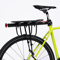 Pannier Rack, attached to a bike, in black aluminum alloy. Dimensions: 50cm, weight: 1350g.