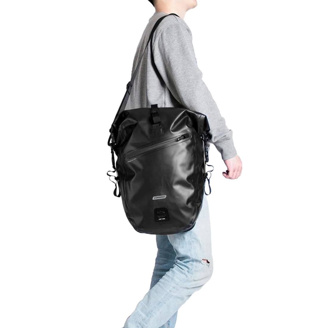 Black Corsino Journey Pannier Bag 27L carried on a shoulder with the included strap, demonstrating its versatile off-bike transport options.