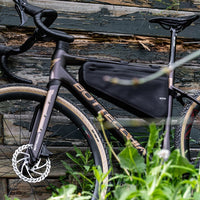 Waterproof black Corsino Excursion Waterproof Bike Frame Bag secured to a gravel bike frame, made from durable 840D Nylon TPU. Equipped with a 3-layer support structure to ensure shape retention under load, and offers both waterproofing and scratch resistance.