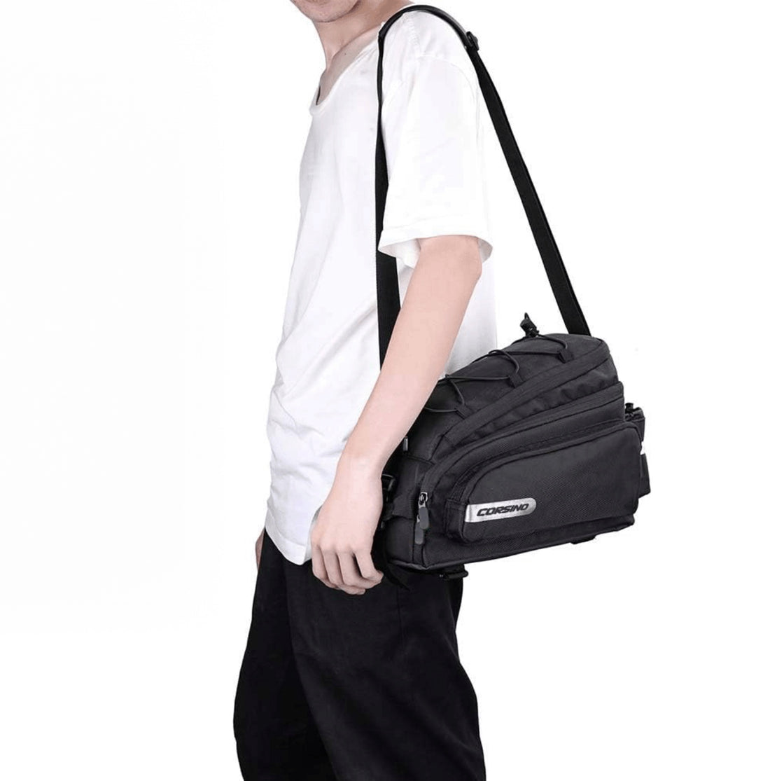 Cyclist carrying the Corsino Adventure Trunk Cargo Bag off-bike using the removable shoulder strap, demonstrating its versatile design for everyday commuting