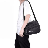 Cyclist carrying the Corsino Adventure Trunk Cargo Bag off-bike using the removable shoulder strap, demonstrating its versatile design for everyday commuting