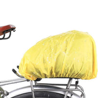 The Corsino Adventure 12L waterproof trunk bag securely mounted to a rear bike rack, fully protected by the included yellow rain cover to keep cycling essentials dry during wet weather rides