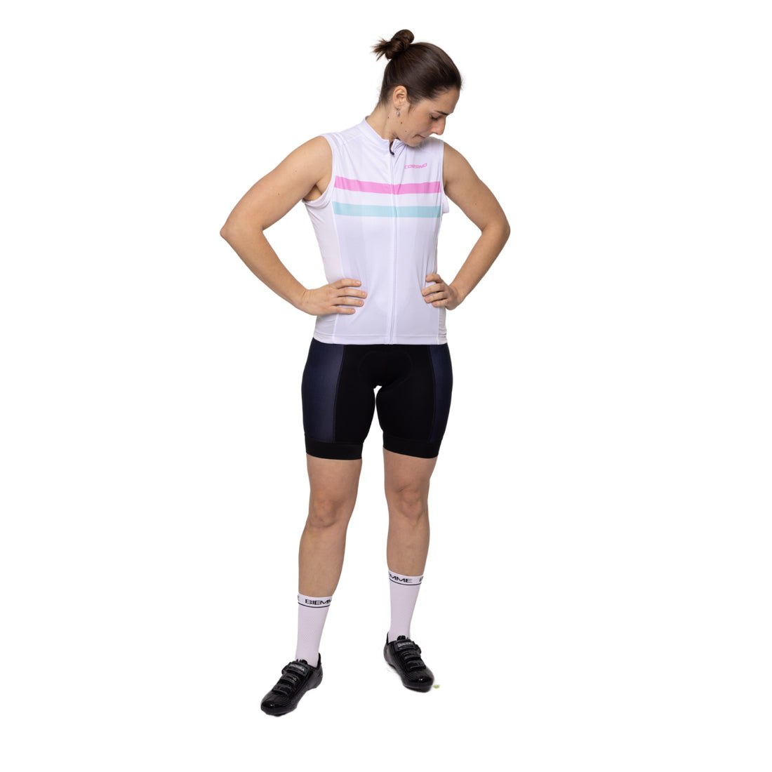 Female cyclist wearing the white, teal, and pink Corsino Elie sleeveless cycling jersey. Demonstrating the aerodynamic comfort fit and highly breathable Technica Coolway fabric that guarantee unrestricted shoulder mobility and rapid core cooling during the hottest summer training rides