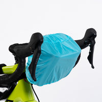 The Corsino Rover camera handlebar bag equipped with its heavy-duty, high-visibility rain cover. Designed to keep expensive photography gear and sensitive electronics completely bone-dry during sudden downpours on the trail
