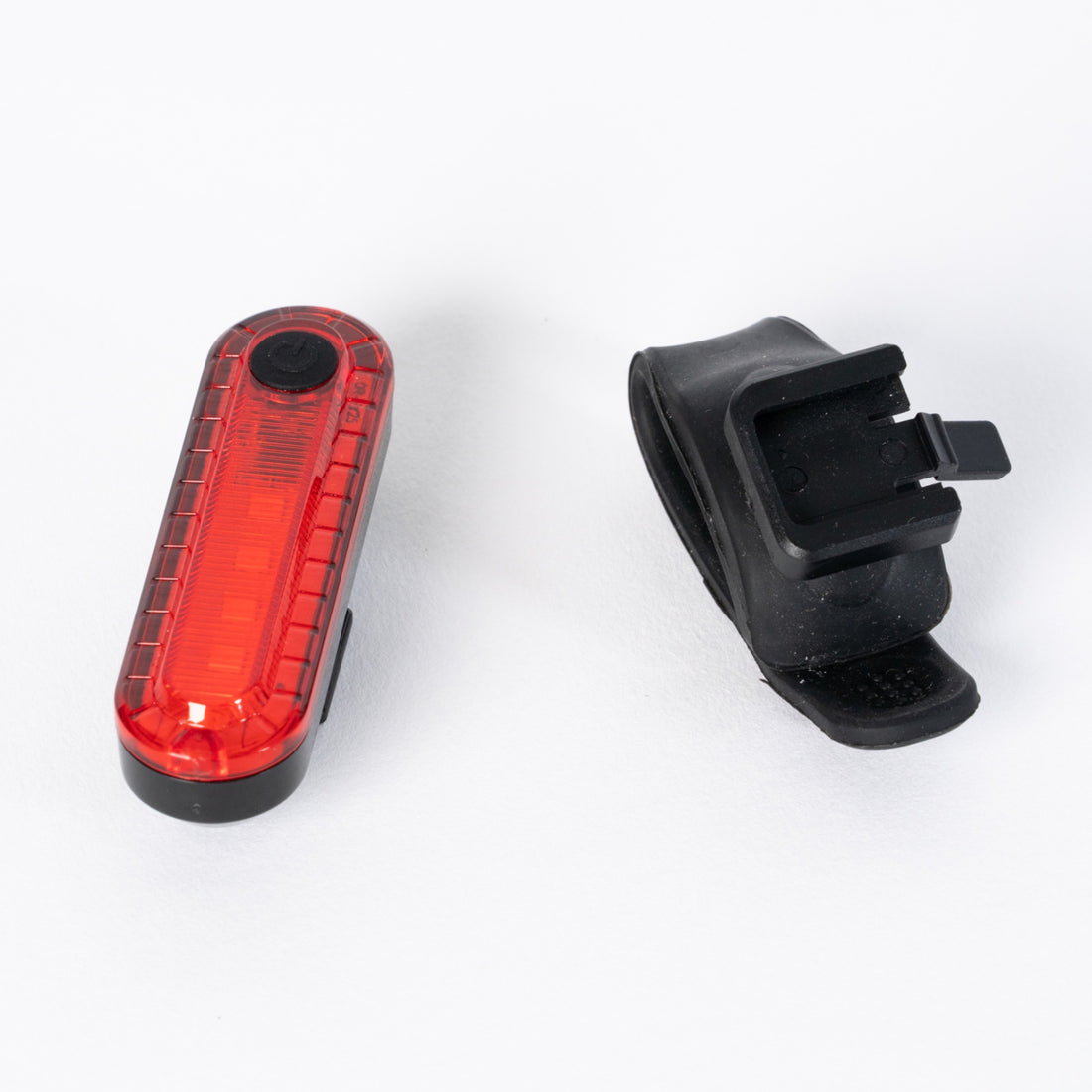 Close-up of the ultra-bright Corsino Spark tail bike light emitting a powerful 50-lumen red beam. Engineered with a highly durable, waterproof ABS shell and a versatile quick-release strap for instant, secure attachment to any seatpost.
